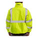 A man wearing a Tingley hi-vis lime yellow and black industrial jacket with reflective panels.