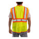 A person wearing a Tingley Hi-Vis lime yellow safety vest with reflective stripes.