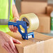 A person using Lavex clear carton sealing tape on a box.