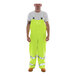 A man wearing Tingley Comfort-Brite yellow rain overalls.