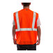 A man wearing a Tingley hi-vis orange safety vest with reflective stripes.