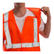 A person wearing a Tingley hi-vis orange safety vest with reflective stripes.