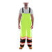 A man wearing Tingley lime yellow safety overalls with black cuffs.