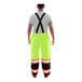 A man wearing Tingley lime yellow safety overalls with black cuffs.