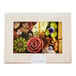 A VerTerra balsa wood catering box with a window lid filled with food, including fruits and flowers.