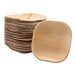 A stack of VerTerra square palm leaf plates on a table.