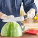 A person using a Mercer Culinary chef knife to cut a watermelon.