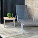 A Three Birds Casual teak side table on a wood deck with a green plant in a pot on top.