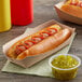 A Kraft paper food tray with a hot dog with ketchup and mustard in it.