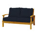 A Three Birds Casual Monterey wooden 2-seater sofa with navy cushions.