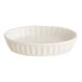 An Acopa ivory porcelain oval dish with a ruffled edge.