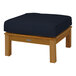 A Three Birds Casual Monterey wooden ottoman with a navy cushion on a wooden surface.