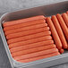 A metal tray filled with Vienna Beef skinless beef franks on a counter.