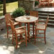 A Three Birds Casual Monterey outdoor bar arm chair on a patio with a table and chairs.