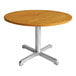 A Three Birds Casual Avanti round teak table with a silver metal base.