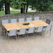 A Three Birds Casual teak dining table with chairs on an outdoor patio.