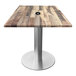 A Holland Bar Stool EnduroTop table with a wood surface and metal base with a metal pole for an umbrella.