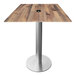 A square wooden table with a brushed aluminum base and metal pole for an umbrella.