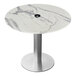 A round white marble table with a silver base.