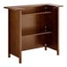 A Lancaster Table and Seating portable bar with a vintage brown finish and shelves.