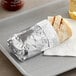 A burrito wrapped in Bagcraft honeycomb foil on a tray.