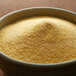 A bowl of yellow Regal Adobo Seasoning without Pepper on a wooden table.