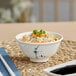 A bowl of rice with vegetables and sauce in an Acopa Bambu Biru melamine rice bowl with chopsticks.