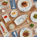 A table with Acopa Biru rectangular melamine plates and bowls of food on it.