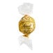 A close-up of a Lindt Lindor white chocolate truffle in gold foil.