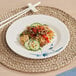 A Bambu Biru melamine plate with food and chopsticks on a place mat.