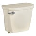 A bone vitreous china American Standard toilet tank with a lid and a silver handle.