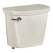 An American Standard linen vitreous china toilet tank with a lid and silver handle.