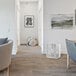 A white VisionAir box fan on a wood floor in a white room.