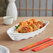 A white Emperor's Select melamine sushi boat with sushi on it.
