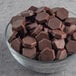 A bowl of Lindt dark chocolate baking chips on a gray surface.