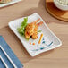 An Acopa Bambu Biru rectangular melamine plate with fried shrimp and rice on it.