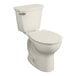An American Standard linen vitreous china round toilet with the seat down.
