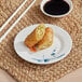 An Acopa Bambu Biru melamine plate with food and chopsticks on a table.