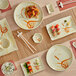 A table with Acopa Brassia melamine plates and plates with sushi on them.