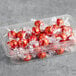 A plastic container with red Lindt Lindor milk chocolate truffles wrapped in red and white.