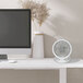 A white VisionAir 6" rechargeable battery-operated table fan on a desk.