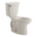 An American Standard linen vitreous china floor-mount chair height toilet with a silver handle.