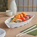 A white sushi boat on a table.