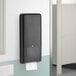 A black Tork PeakServe continuous paper towel dispenser on a wall.