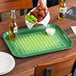 A rectangular Cambro tray with a football field design, filled with food and beer on a table.