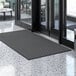 A black Lavex parquet entrance mat with a black border on a marble floor.