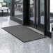 A gray Lavex parquet entrance mat on a floor.