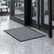 A gray Lavex indoor entrance mat in front of a door.