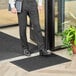 A man in a suit standing on a black Lavex Waffle indoor entrance mat.