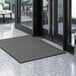 A gray Lavex parquet entrance mat on a marble floor.